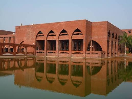 An IUT hall reflected in the campus water court.